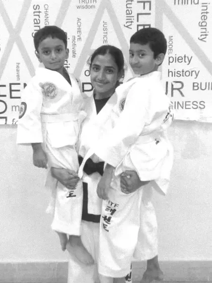 One of our female black belt instructors with two of her young students, showcasing the supportive and inspiring environment we create.