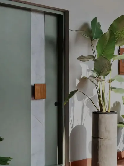 The main door is the first handshake of a home. Here, we combined a calming sage green with a central stripe of white marble and a solid wood handle, creating an entrance that is modern, natural, and welcoming.