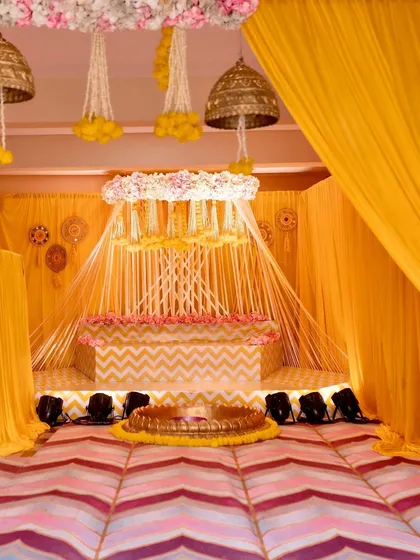The full view of the 'Arisina' shower decor we created. The setup includes a canopy of hanging floral strings, a chevron-patterned stage, and a beautiful lotus tub at the center.