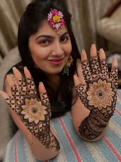 Nothing makes me happier than a smiling client. Here she is, showing off her full-hand mandala mehandi, perfect for a sangeet or wedding function. The design is symmetrical and very detailed.