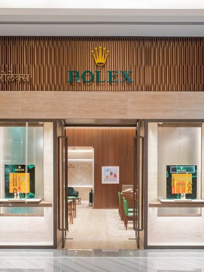 The entrance to the Rolex flagship boutique in Mumbai is designed with restraint and sophistication. Warm wood tones and travertino cladding create a welcoming yet exclusive feel, resonating with Rolex's global ethos of timeless elegance.