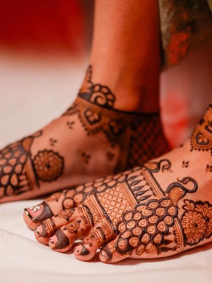 A close-up of traditional peacock mehendi on the feet, a timeless choice for any bride.