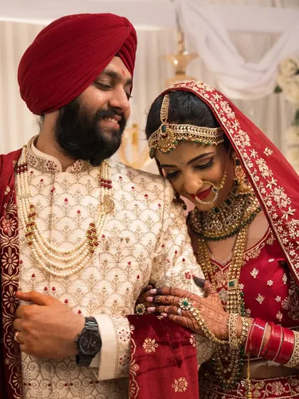 An intimate moment between the Sikh bride and groom, highlighting the intricate details of their wedding outfits and jewelry.