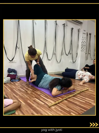 A gentle, hands-on adjustment helps this student relax deeper into a restorative pose.