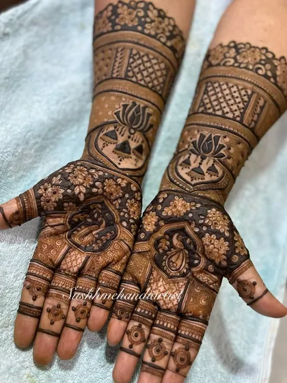 This design features bold lotus motifs on the forearms and intricate figures on the palms. The contrast between bold and fine lines is something I love to play with.