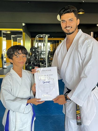 Presenting a certificate of merit to a student who has shown great improvement and passed his grading.