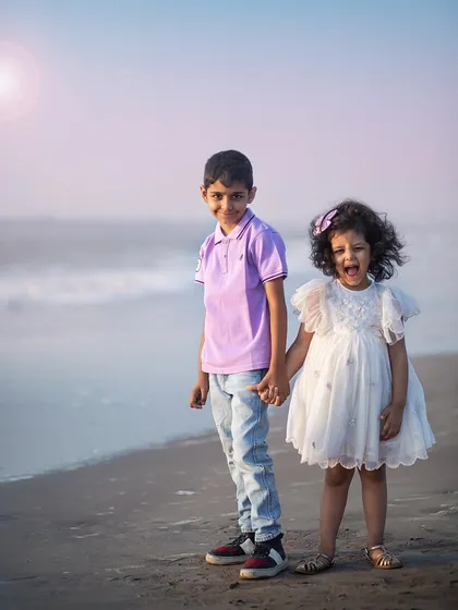 A fun and candid moment between brother and sister at the beach. Her joyful expression is absolutely infectious!