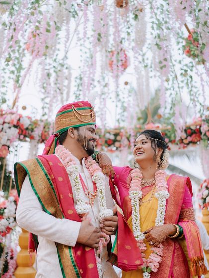 A joyful moment between the bride and groom under a beautiful floral mandap.