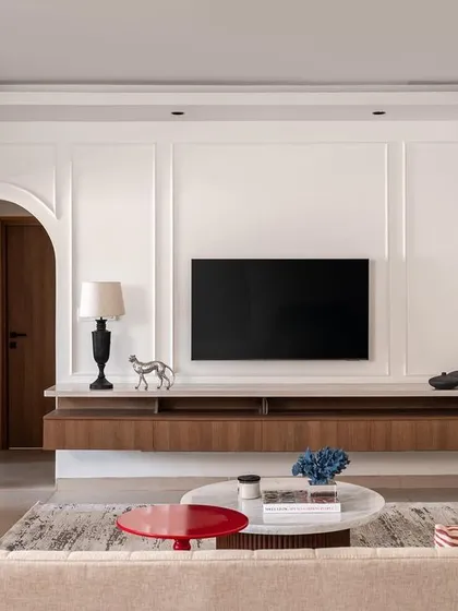 This living room from 'Project Dolce' was designed for a young family, blending contemporary style with practical needs. The space features clean lines, wall paneling for texture, and a floating console to maintain an open feel, proving that a family home can be both sophisticated and functional.