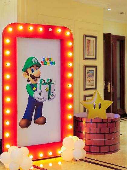 Another shot of the custom light-up Luigi sign, paired with a power star prop. These illuminated elements add a professional and exciting touch to the party decor, especially for evening events.