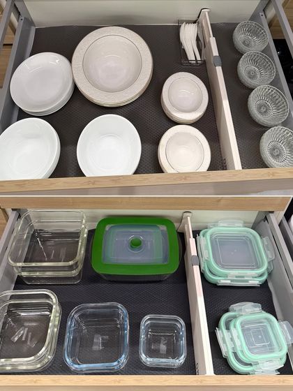 Two drawers showing organized daily-use bowls and glass storage containers. Using drawer liners helps prevent items from sliding around.