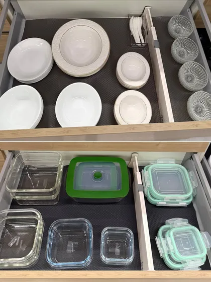 Two drawers showing organized daily-use bowls and glass storage containers. Using drawer liners helps prevent items from sliding around.