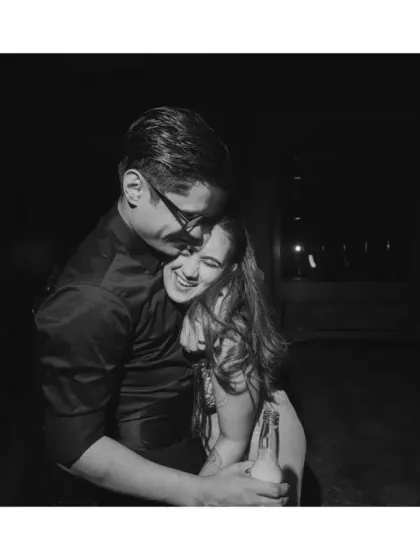 The after-party glow. In the quiet moments after the wedding chaos, the couple shares a hug. Black and white strips away the distractions, focusing purely on their newlywed joy and connection.