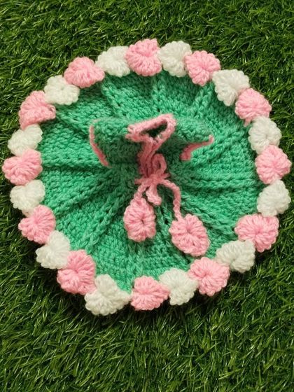 This cozy winter dress is made with green wool and features a border of delicate pink and white flowers. It's a soft and warm choice for your Kanha Ji.