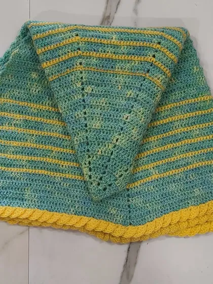 The lime green and yellow shawl folded to show its points.