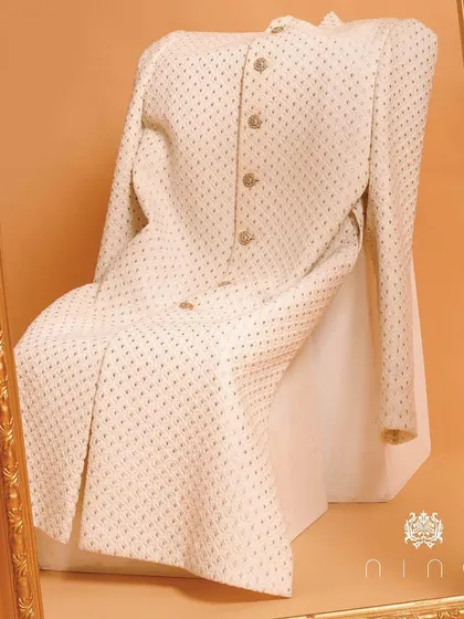 Framed like a work of art, this ivory sherwani is a testament to our craft. The subtle all-over embroidery and classic silhouette make it a timeless choice for a groom who values elegance.