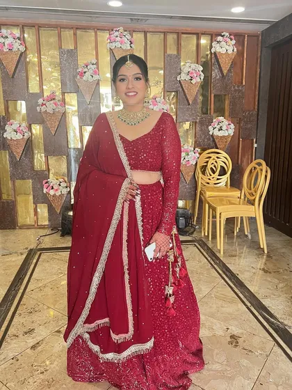 A full-length shot showing the entire classic red lehenga look.