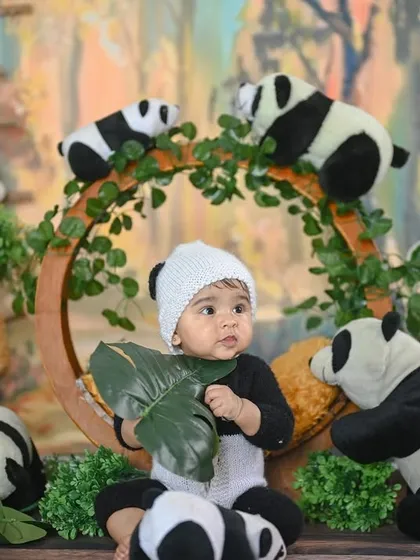 This little panda is curiously exploring a leaf. These candid, interactive moments make for wonderful photos.