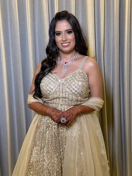 A happy bride, her makeup looking flawless and radiant. The statement ruby necklace is the perfect accessory.
