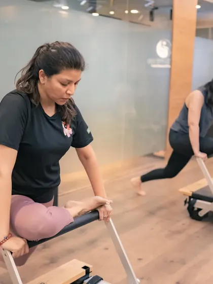 A pigeon pose variation on the reformer allows for a deep, supported stretch of the hip rotators and glutes. This is key for improving mobility and relieving lower back tension.