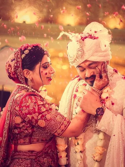 A fun, candid moment from the varmala ceremony, capturing the bride's playful gesture.