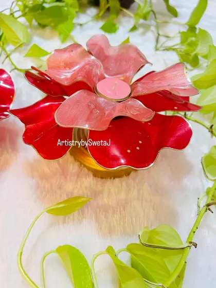 The floral diya used as a T-light holder, with a candle glowing softly in the center.