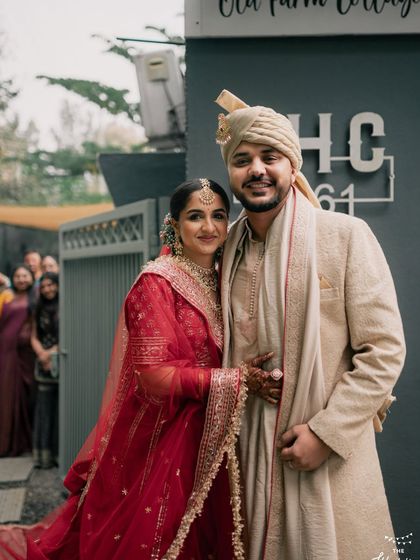 A happy couple poses in front of the 'FHC 1961' sign, a signature spot at our venue. This is a great photo opportunity to remember your special day.
