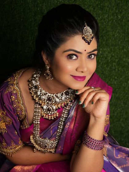 A close-up portrait of a bride wearing a Victorian-style set with dark stones. The antique finish looks very elegant.