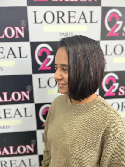 The client is smiling, happy with her fresh, short bob haircut. It's a low-maintenance style that always looks sophisticated.