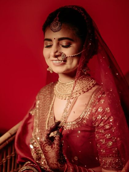 A close-up of the bride, her eyes closed in a moment of quiet happiness. The warm red light enhances the romantic and intimate feel of the portrait.