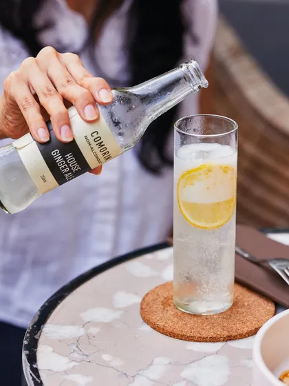 Our house-made ginger ale being poured, a crisp and spicy non-alcoholic option that pairs beautifully with our vibrant food menu.