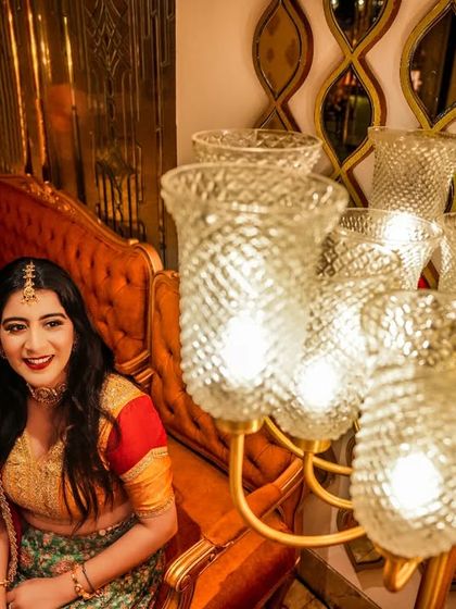 The bride-to-be glowing next to an ornate chandelier. I love using ambient light and decor to frame my subjects, creating a warm and inviting atmosphere for the portrait.
