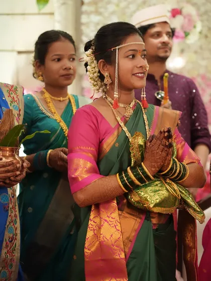 The bride stands ready for her wedding rituals. Her makeup is fresh and natural, allowing her own beauty to shine through.