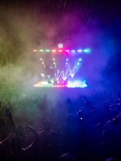 A hazy, dreamlike stage atmosphere created with colored smoke and dynamic lighting for Alan Walker's set.