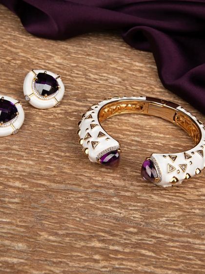 The modern white and purple stone jewellery set placed on a wooden surface with purple fabric, showcasing the product in a lifestyle context.