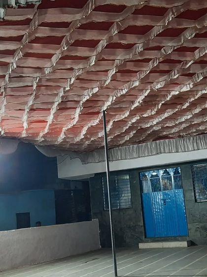 A simple white and red patterned ceiling for a pandal. This is a cost-effective way to cover a large outdoor area.