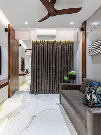 A view of the den area in the Filigree House, showcasing the comfortable leather sofa and rich textures. The space is designed as a cozy haven of sophistication for relaxation.