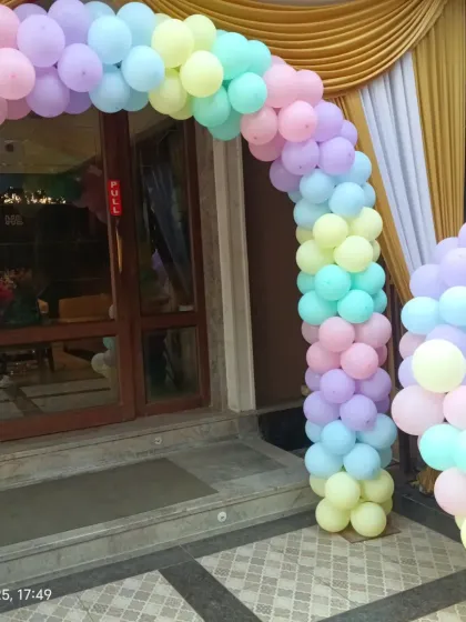 A pastel rainbow balloon arch marks the entrance to this princess-themed birthday party.