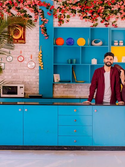 A stylish couple poses in our vibrant and modern kitchen set.