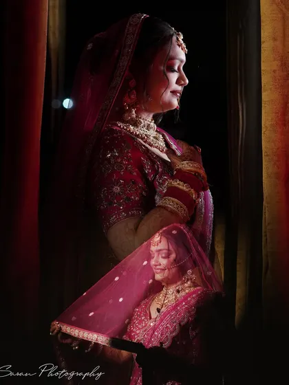 A double-exposure portrait of the bride in a dark, intimate setting, blending two different expressions.