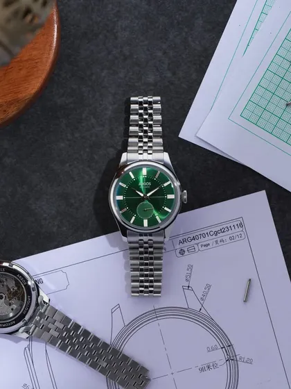 A "work in progress" flat lay. This shot places the Argos watch among technical drawings and tools, telling the story of its design and creation. It connects the final product to the craft and precision behind it.