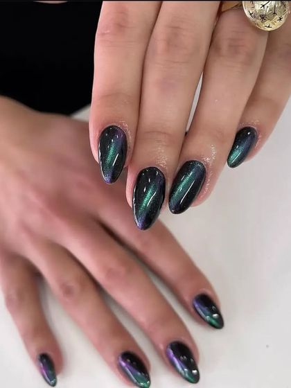 A mesmerizing "cat eye" effect on almond-shaped nails, with a magnetic polish that creates a green and purple shimmer.