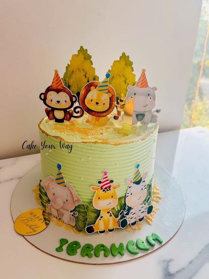 The cutest jungle crew is ready to party on this light green cake, perfect for a safari-themed celebration.