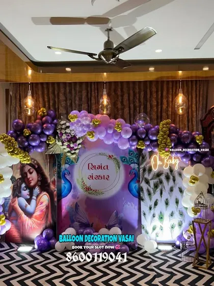 This baby shower decoration has a beautiful spiritual theme, featuring an image of Krishna and a peacock-feather-inspired design. The purple and gold balloons add a rich, royal feel to the event.