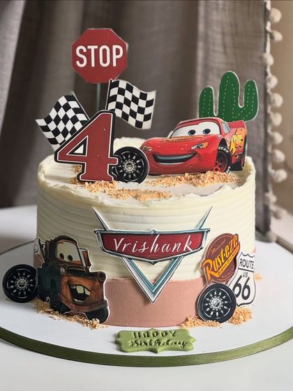 Ka-chow! This "Cars" themed cake brings Radiator Springs to the party for a 4th birthday. Featuring Lightning McQueen and Mater, it's perfect for any little racer's big day.
