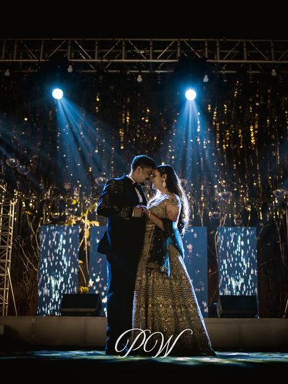 A spotlight moment for the happy couple. The stage lighting and glittering backdrop were designed to make them the stars of their Sangeet night.