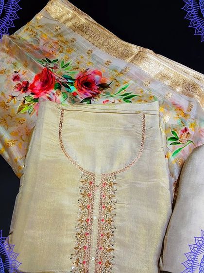 An elegant off-white unstitched suit set. The top has delicate embroidery, and it is paired with a stunning digital floral print dupatta with a golden border.