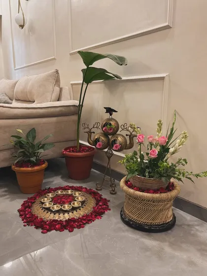 Even the smallest details matter. This cozy corner setup features a floor rangoli made of fresh rose petals and diyas, along with a small floral arrangement, adding a touch of traditional elegance to the home.