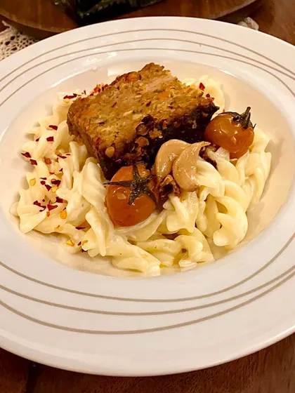 My pork meatloaf is incredibly versatile. Here, it’s served over a simple Aglio Olio pasta with roasted cherry tomatoes and garlic, making for a quick and elegant supper.