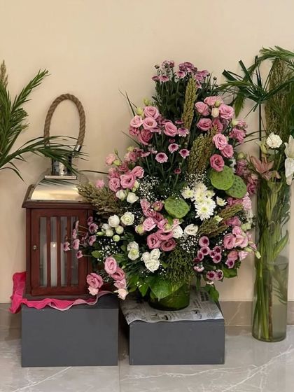 A grand floral arrangement perfect for an entryway or a statement corner. The mix of pink roses, lilies, and dramatic greenery creates a breathtaking display of natural beauty.